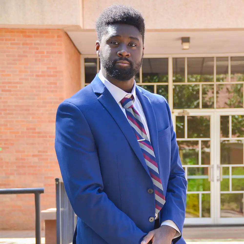 COBA student poses in front of building.