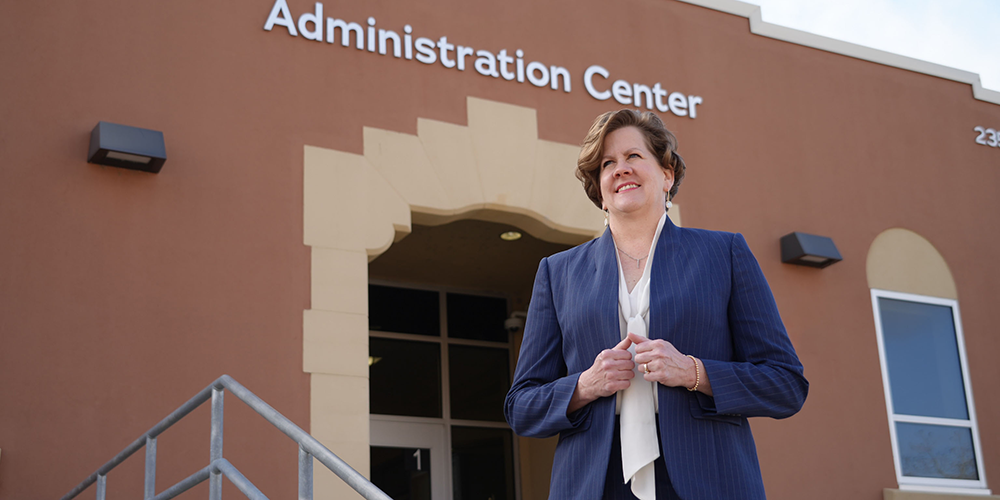 ​​Professional woman standing in front of a brick building​ 
