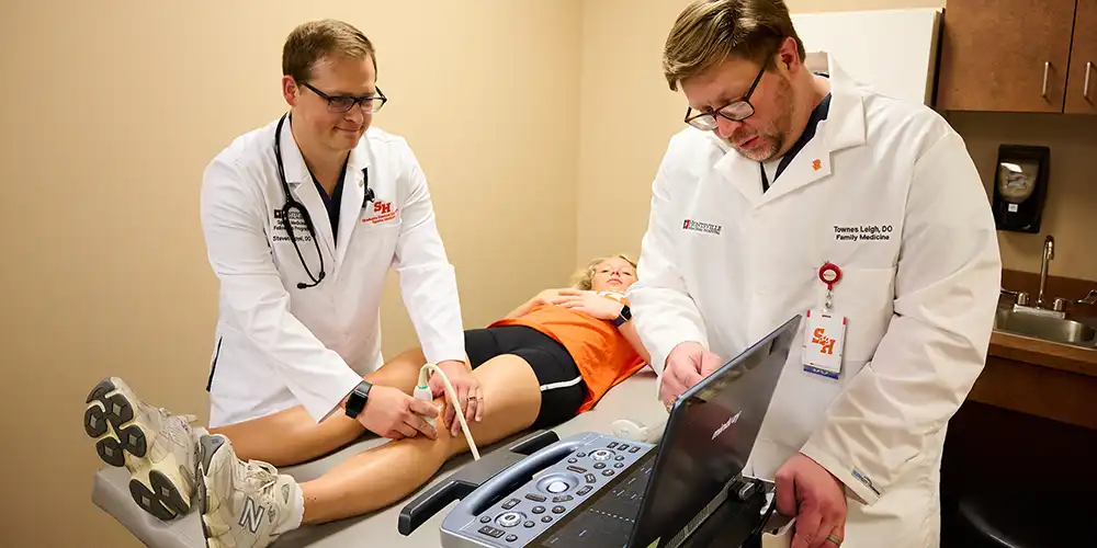 Fellow with a patient and an attending doing an ultrasound