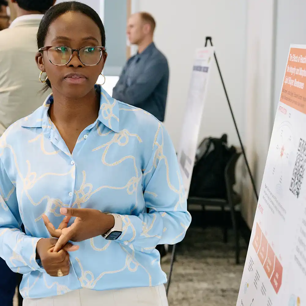 Student looking at research poster while presenting