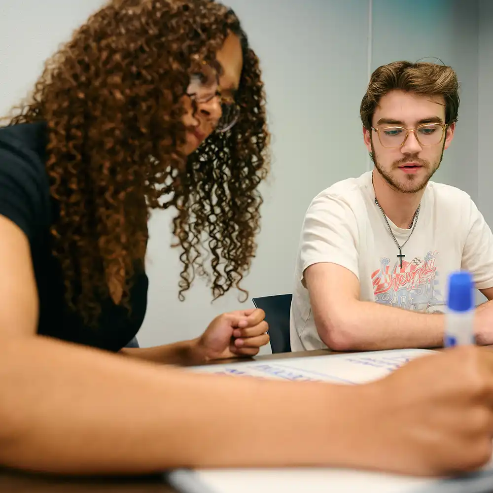 SHSU students in conversation in the College of Humanities and Social Sciences building.