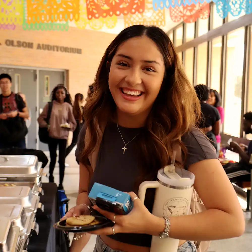 Student enjoys food atthe  Hispanic Heritage Month celebration.