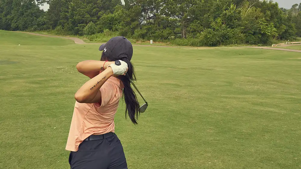 Women swinging a golf club