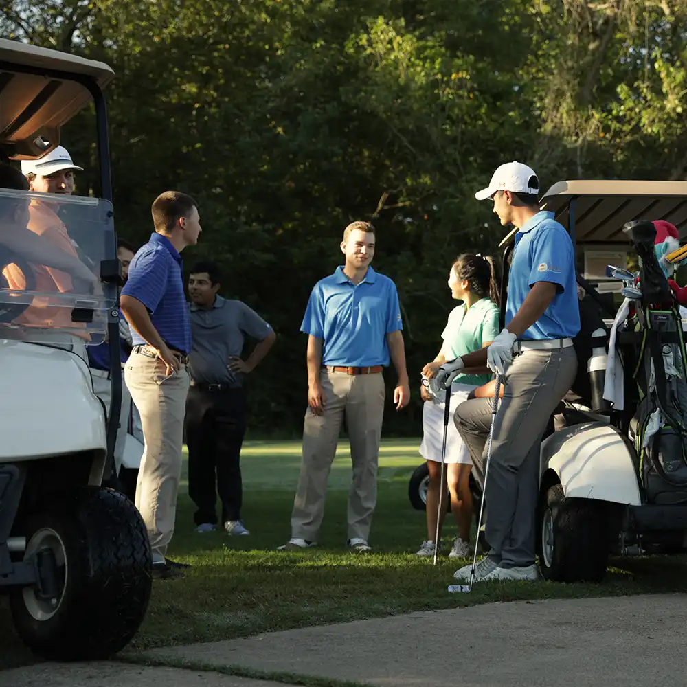 Two women looking at each other, smiling, sitting down, working on an assignment.
