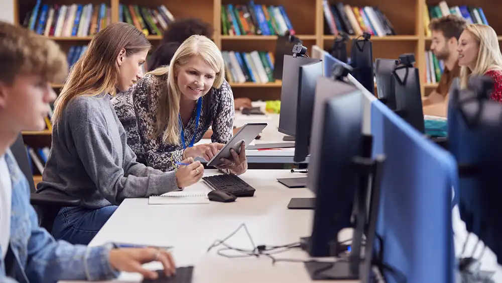Group of people working together at computer stations. 