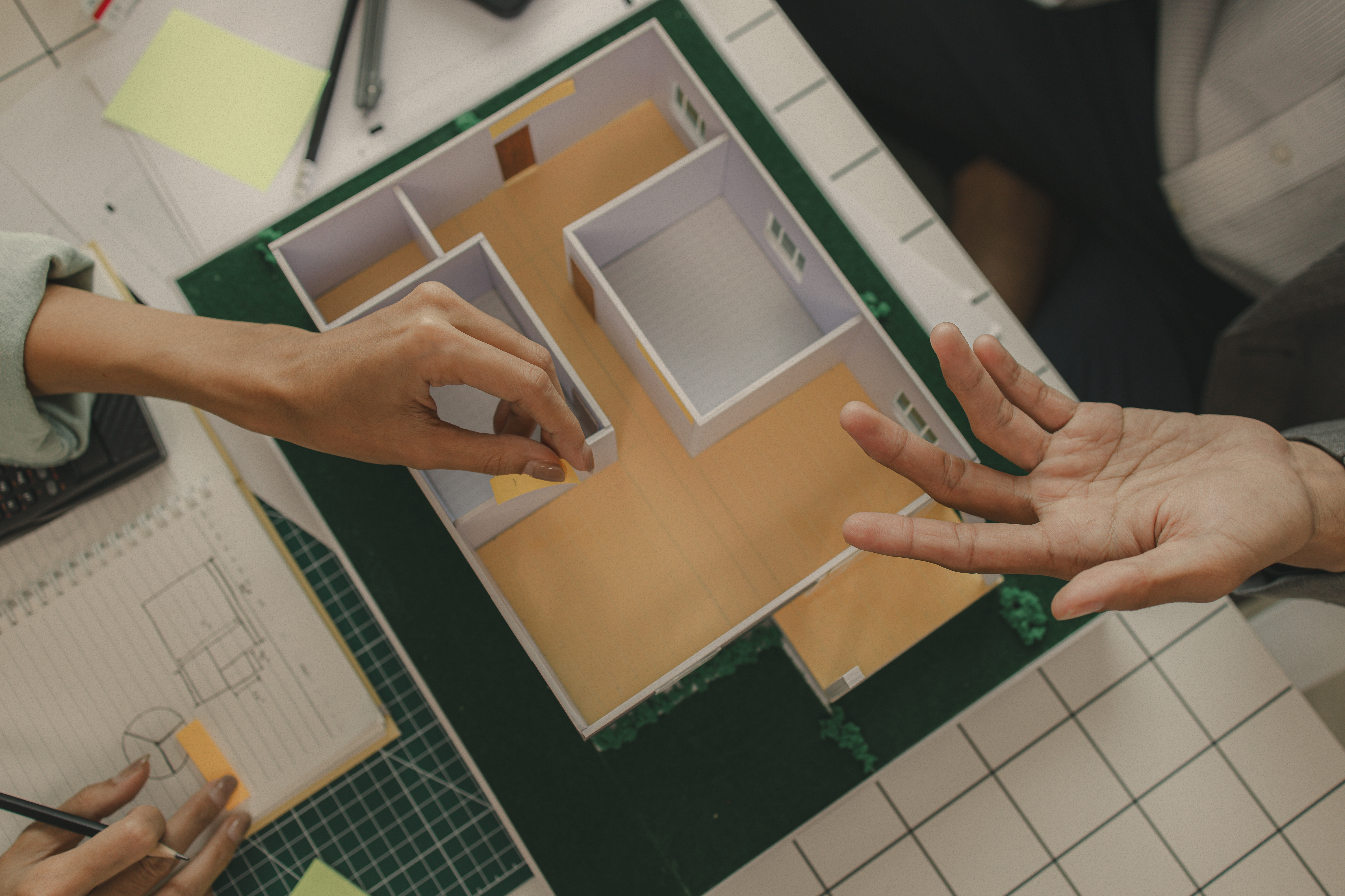 Two women looking at each other, smiling, sitting down, working on an assignment.