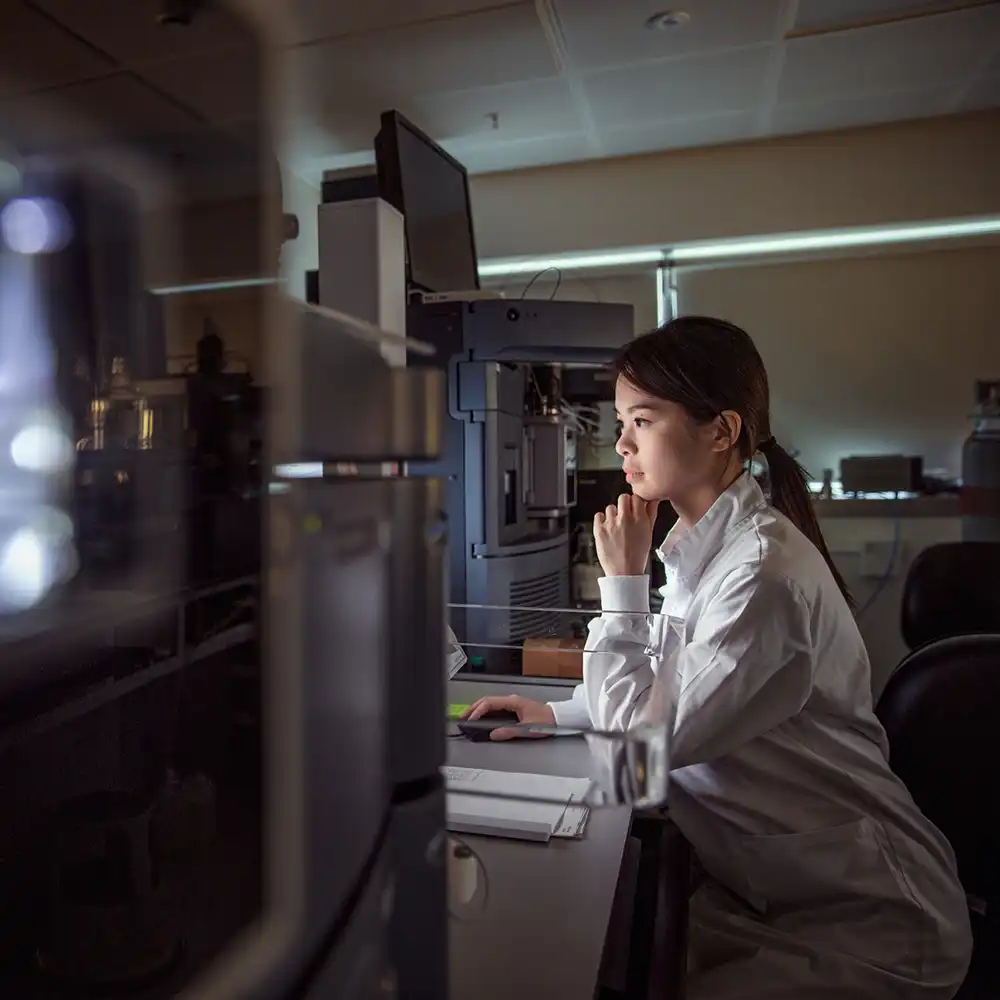 Woman looking at a computer screen in a lab. 