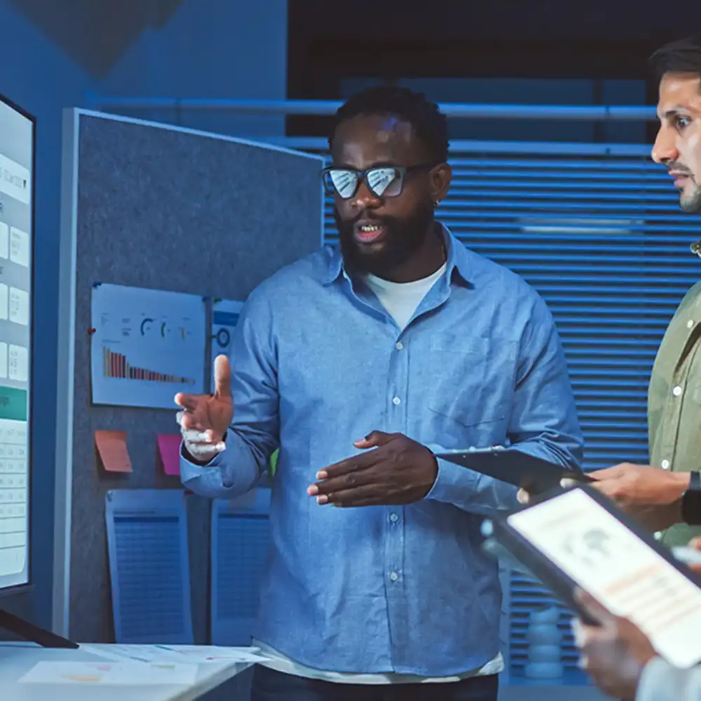 Two women looking at each other, smiling, sitting down, working on an assignment.