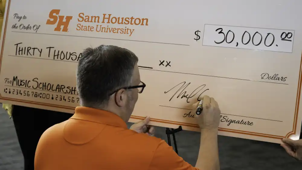 donor signing a giant check