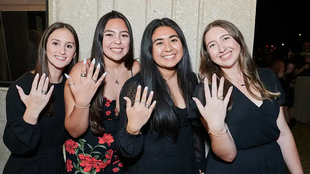 students posing with graduation rings