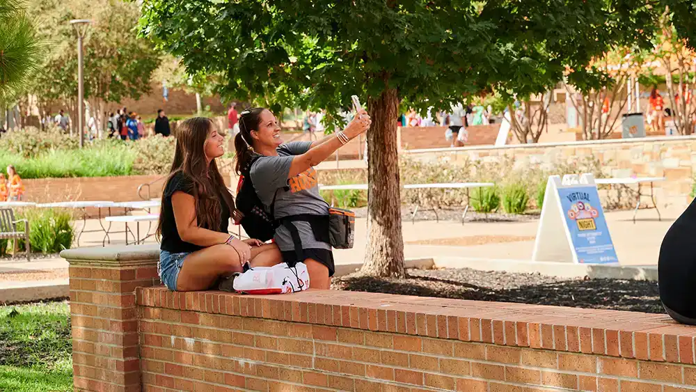 Two female students taking a photo together.