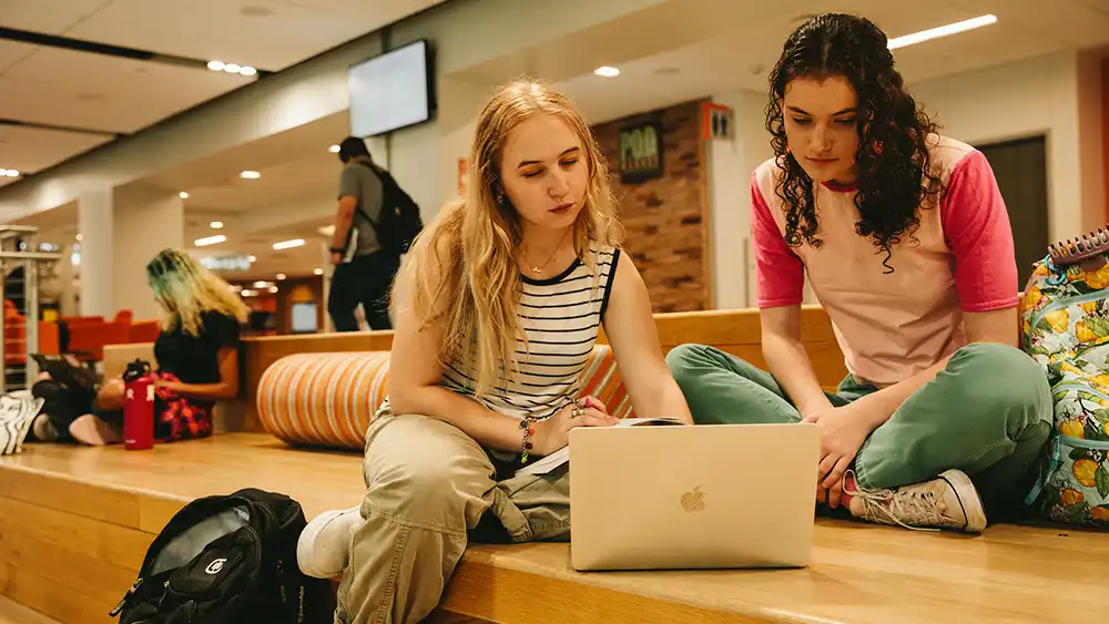 Two female students looking at a computer.