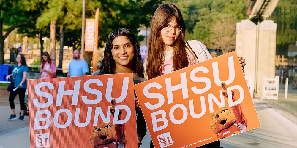 Two female students holding signs