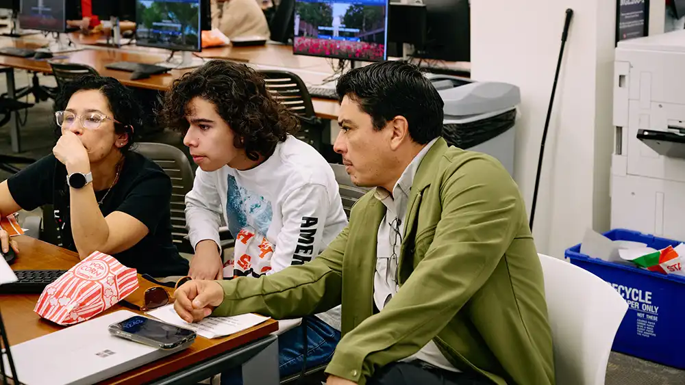 Faculty member sitting with students.