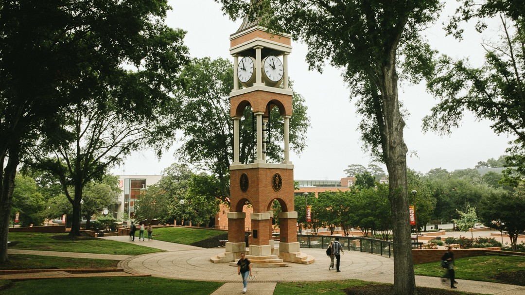 students walking near bell tower