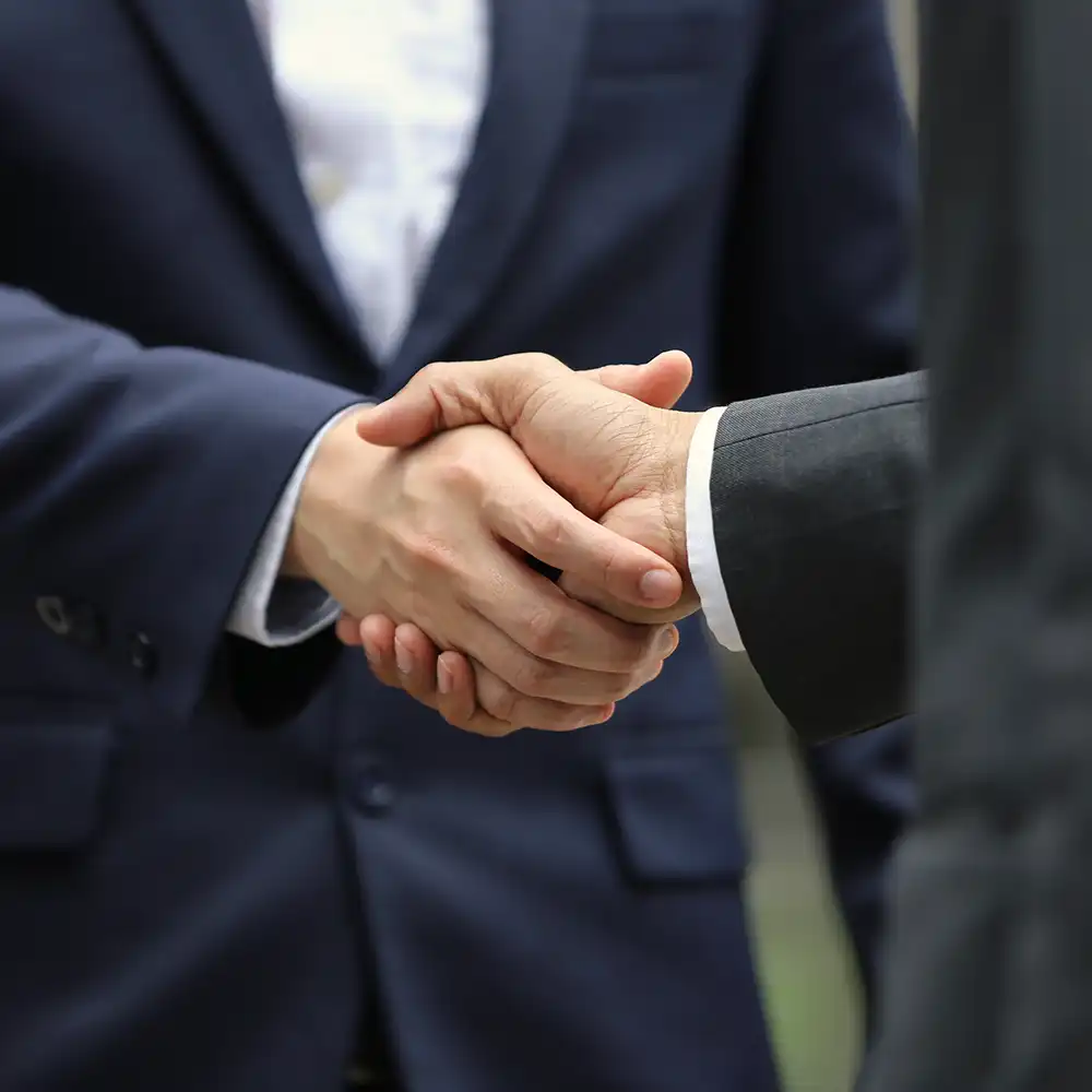 ​​A handshake between two people in an office​ 