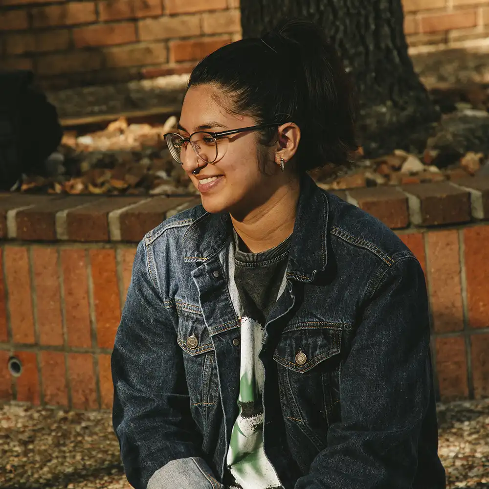 ​​A girl with the quote, “without Freedom of Speech, there can be no change”​ 