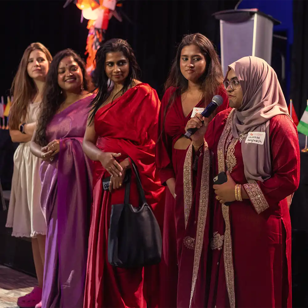 SHSU international students holding their home country flag during Home Coming parade.