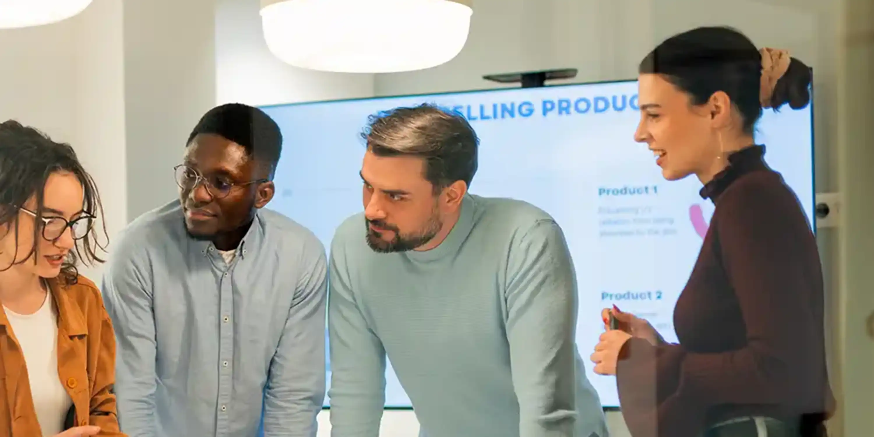 Group of people around a desk working together. 
