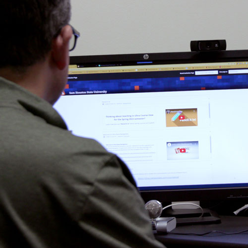 Instructional designer works on computer to copy courses in Blackboard for the upcoming fall semester.