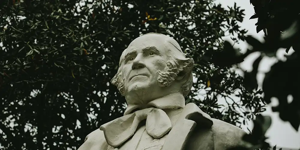 Statue of Sam Houston located on the university grounds, surrounded by dense foliage.
