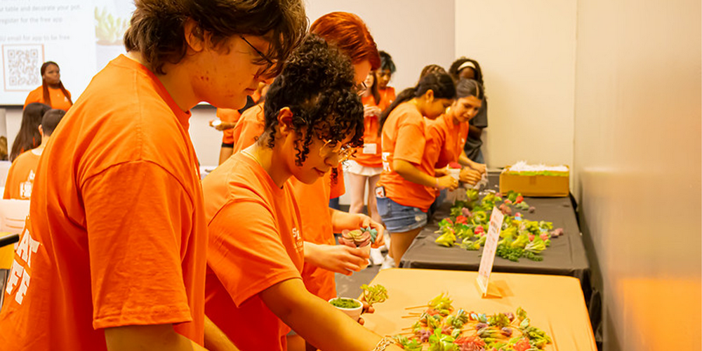 Students participating in an event at Bearkat Kickoff, building their own succulents.