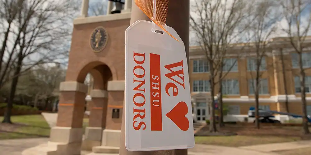 A tag reading "We love SHSU donors" hangs near the Blatchley Bell Tower